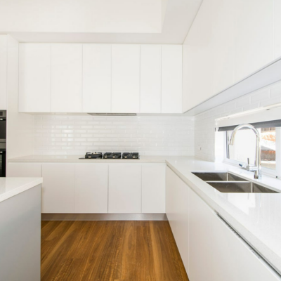 kitchen with large white benchtops,with gas cook top and double stainless steel sink
